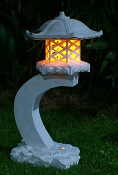 a small white lantern sitting on top of a lush green field