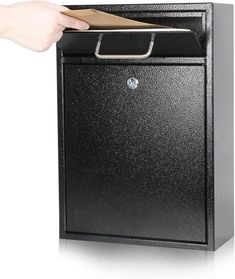 a person is holding a card in front of a black box with a brown paper sticking out of it