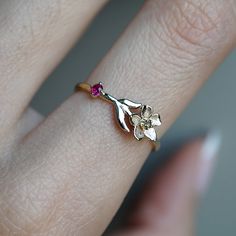 a woman's hand with a flower ring on it