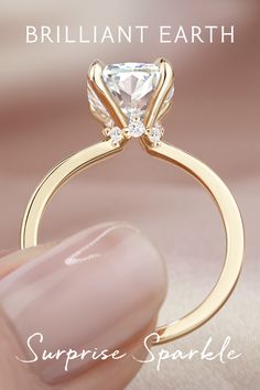 a close up of a person holding a ring with a princess cut diamond on it