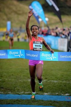 a woman crosses the finish line in a race