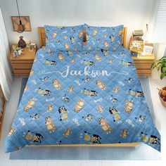 a blue bed with cartoon characters on it and the name jackson written in large letters