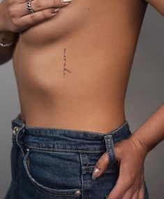 a woman's stomach with the word love tattooed on her left side, in front of her right breast