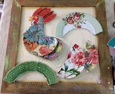 several plates are arranged in a wooden frame on the table next to scissors and other crafting supplies