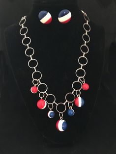 This piece is Handmade 70s costume Jewellery perfect for 4th of July This necklace was made using a delicate silver chain and vintage red, white and blue sphere buttons. The clasp is a tube style closure and it is not adjustable.  The sphere buttons were part of the amazing collection I received from my mother in law. Making jewellery is also a passion of mine, using all the amazing items I inherited from her brings me joy to use in my jewellery.  The earrings are also vintage, the button earrings had clip backings but I replaced the clips with pierced posts. Necklace Length: 18.5 inches around Vintage Red White And Blue, Sphere Necklace, 70s Costume, 70s Jewelry, Mod Jewelry, Patriotic Jewelry, Making Jewellery, Button Earrings, Steel Jewelry