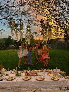 a group of people standing around a table covered in plates and bowls with food on it