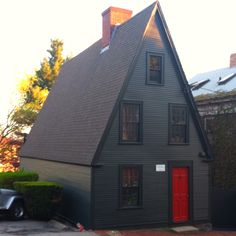 a gray house with red door and windows