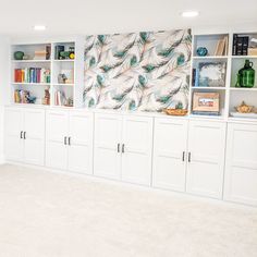 an empty room with white cabinets and bookshelves