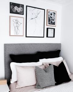 a bed with pillows and pictures on the wall