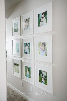 a white wall with pictures hanging on it's sides and the bottom half is filled with photos