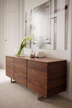 a large wooden cabinet sitting in front of a mirror on top of a white wall