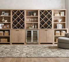 a living room filled with lots of furniture and wine bottles on top of wooden shelves