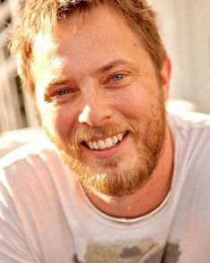 a close up of a person with a tooth brush in his hand and smiling at the camera