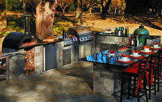 an outdoor kitchen with lots of counter space and chairs around the barbeque area