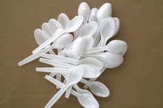 plastic spoons are arranged on a brown surface