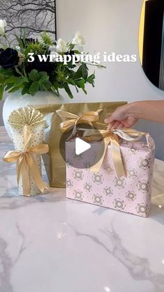 a person opening a gift box on a table with flowers in the background and text overlay that reads, 3 wrapping ideas