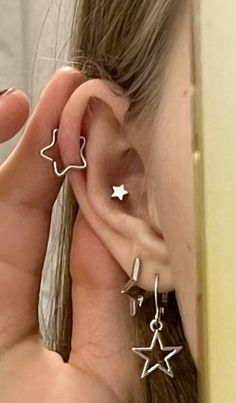 a woman wearing ear piercings with stars on them