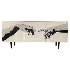 an art piece with two hands reaching out to each other, on top of a wooden table