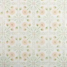 a white tiled wall with pink and green flowers painted on the tiles in different colors