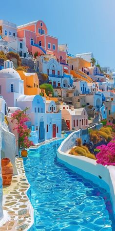 the water is blue and there are many buildings on the hill behind it that look like they have been painted in different colors