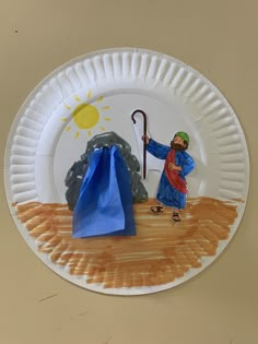 a paper plate with a man holding an umbrella and blue bag on the ground next to it