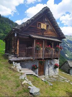 an old log cabin with flowers on the balconies