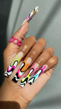 a woman's hand with multicolored nails and nail art on her fingers