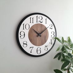 a clock on the wall with numbers and numerals in black and white colors