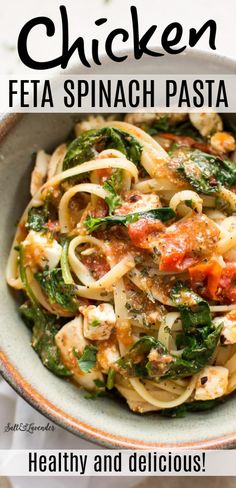 a bowl filled with pasta and spinach on top of a table