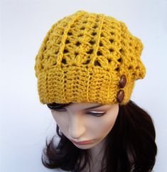 This lacy slouchy hat is made with acrylic yarn in mustard yellow. The hat fits baggy in the back but has a stretchy band around the bottom to hold it on your head without sliding off. It is accented with copper carved buttons. Perfect for chilly fall nights around the fire. Yellow Brimmed Crochet Hat, One Size Fits Most, Yellow Brimmed Crochet Hat One Size, Yellow Crochet Hat For Winter, One Size, Winter Yellow Crochet Hat, One Size, Yellow One Size Brimmed Crochet Hat, Yellow Crochet Cap Hat, Yellow Adjustable Crochet Cap, Adjustable Yellow Crochet Cap, Yellow One-size Brimmed Crochet Hat