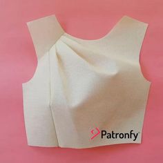 the back of a white top with an open neckline on a pink background that says patronfy