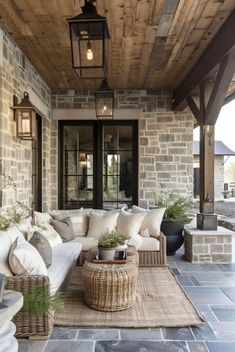 an outdoor living area with couches, tables and lamps on the outside wall in front of