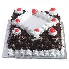 a chocolate cake with white frosting and cherries