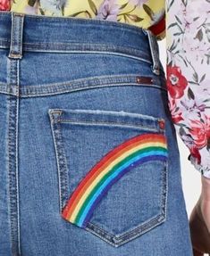 a woman in floral shirt and jeans with rainbow pocket