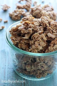 a glass bowl filled with granola on top of a wooden table