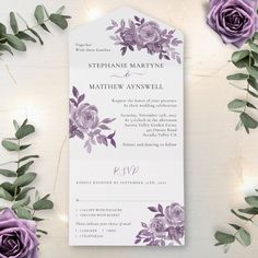 a wedding card with purple flowers and greenery