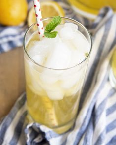 a glass filled with ice sitting on top of a table next to sliced lemons