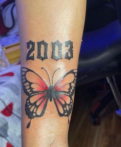 a woman's arm with a butterfly tattoo on it and the year 2013 written in black ink