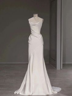 a white wedding dress on display in a room