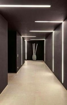 an empty hallway with white lights and vases on either side in front of it