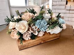 a wooden box filled with flowers on top of a table