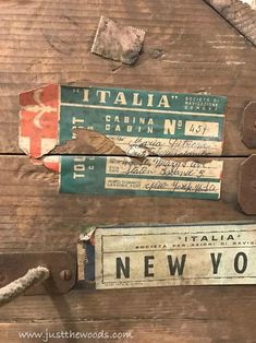 some old wooden signs hanging on the side of a wood wall with rope attached to them