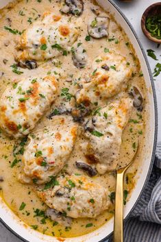 a pan filled with chicken and mushrooms covered in gravy