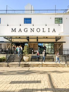 people walking in front of a building with the name magnanolia written on it