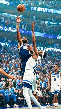 two men playing basketball in front of an audience