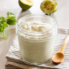 a glass jar filled with food sitting on top of a table next to an avocado