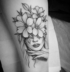 a woman's face with flowers in her hair on the arm and behind her head