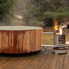 a person standing next to a hot tub on top of a wooden deck