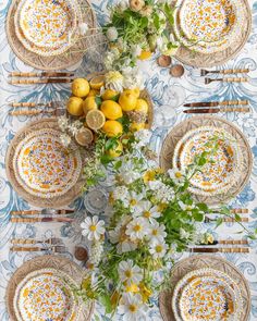 an overhead view of a table with plates, flowers and lemons on the table