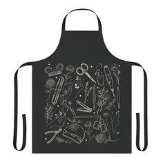 an apron with scissors and other items on the front, in white ink against a black background